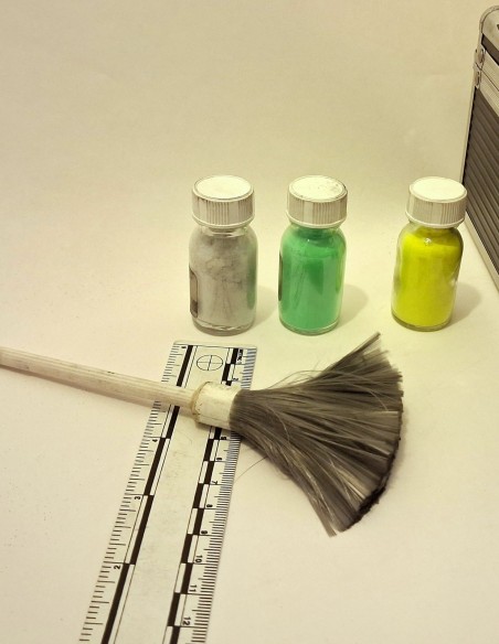 Pinceau à empreintes fibre de verre posé sur une réglette, devant trois poudres de révélation
