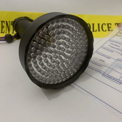 Lampe UV 128 LEDs, tête à 128 diodes vue de face, posée sur une scène de crime