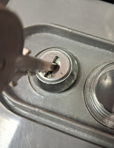 Gros plan : la clé T10 entre dans la serrure d'une batterie de boîtes aux lettres